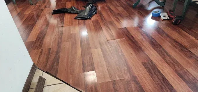 Wood flooring with tools and a wall in the background.