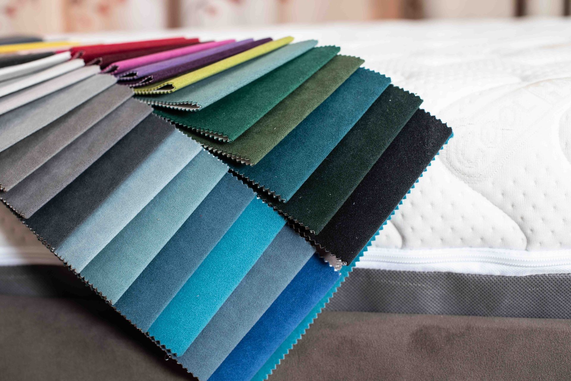 A mattress with a bunch of different colored fabrics on it.