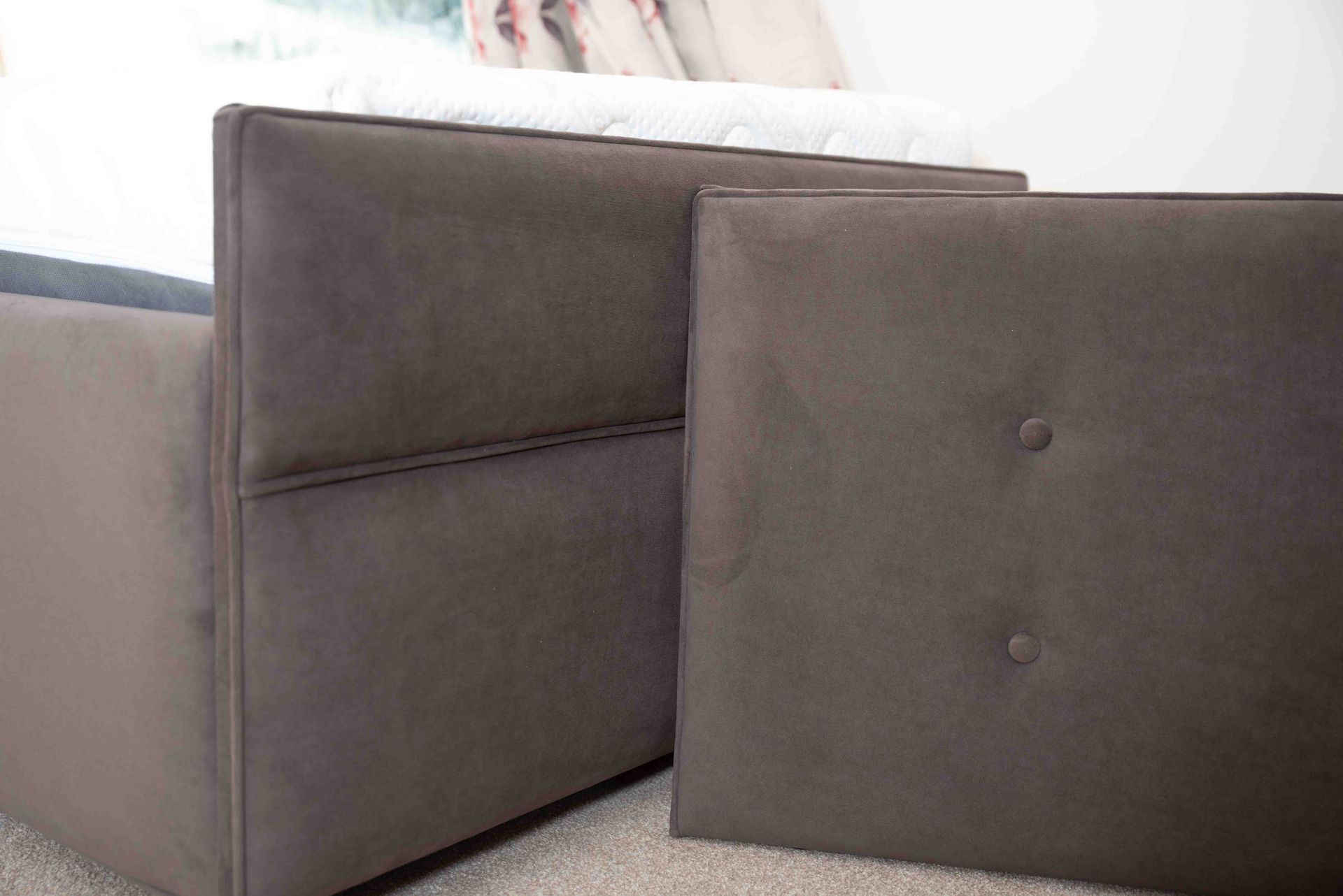 A close up of a bed with two headboards in a bedroom.