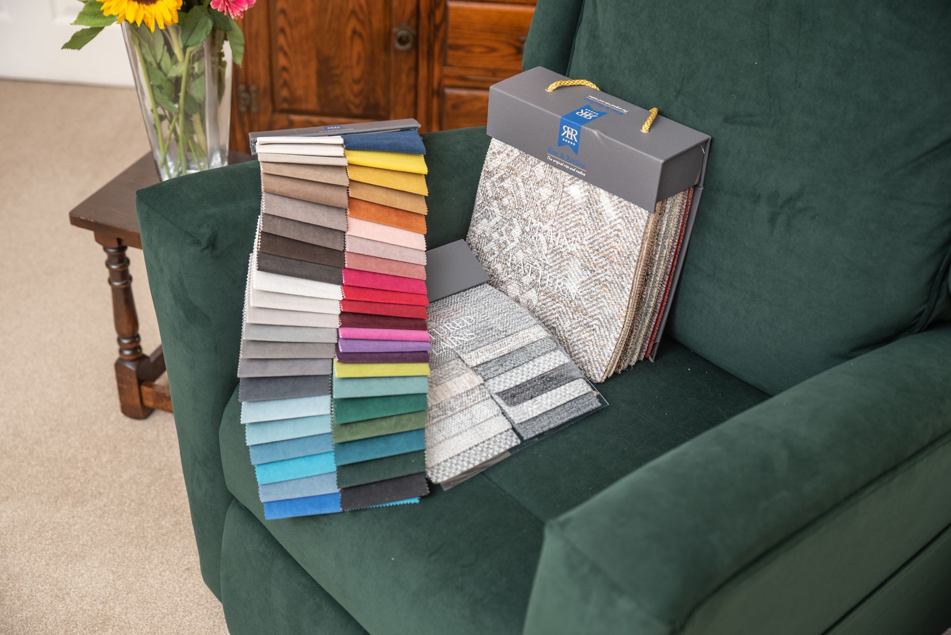 A green chair with a box of fabric samples on it