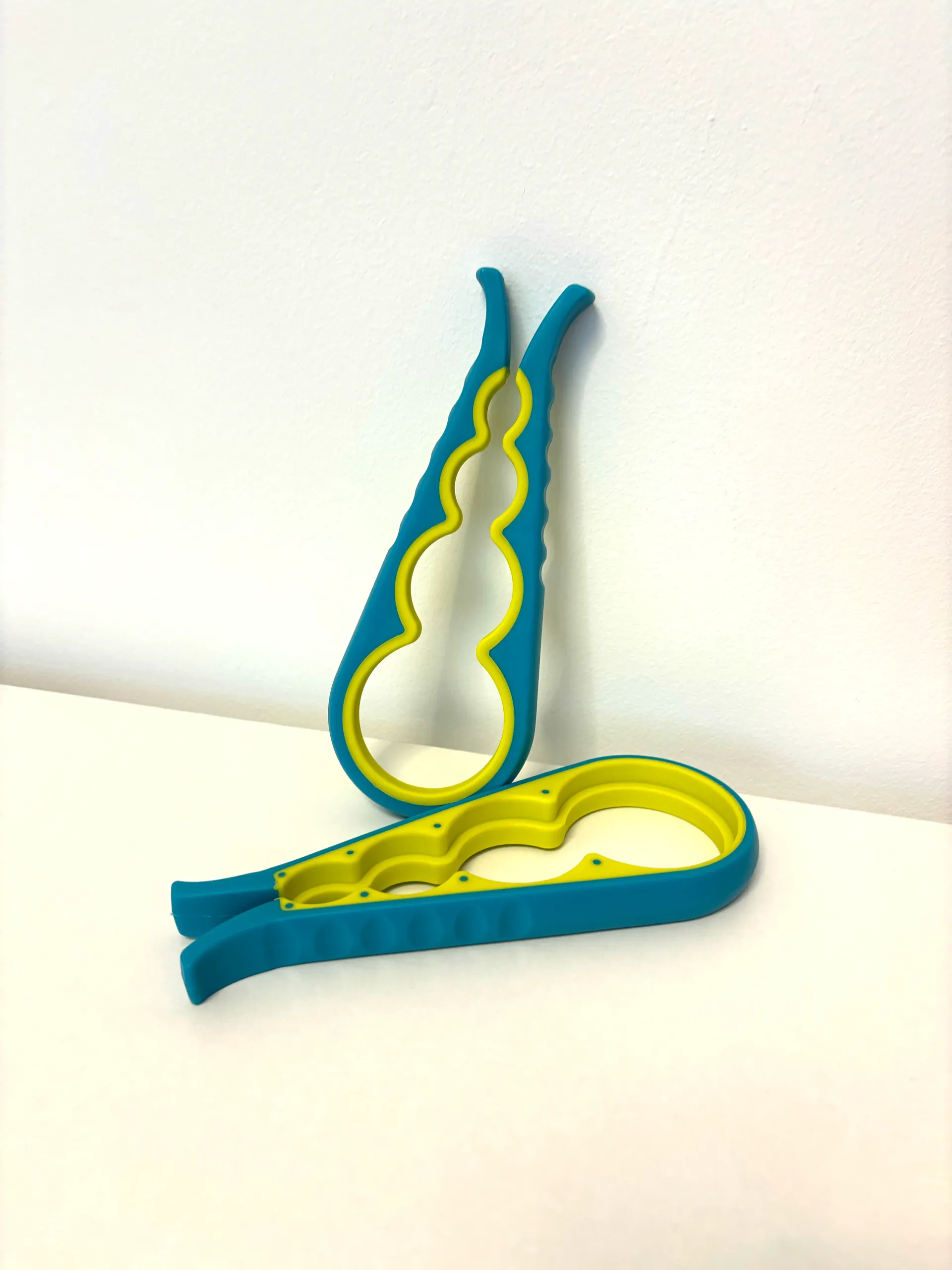 A pair of blue and yellow bottle openers on a table