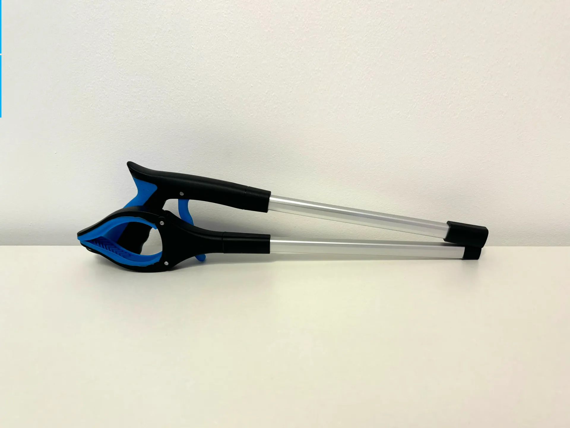 A blue and black tool is sitting on a white table.