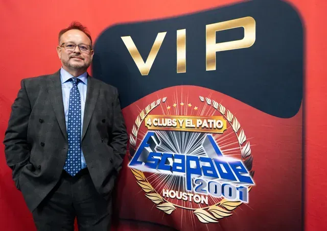 Man in suit standing in front of a VIP sign with 