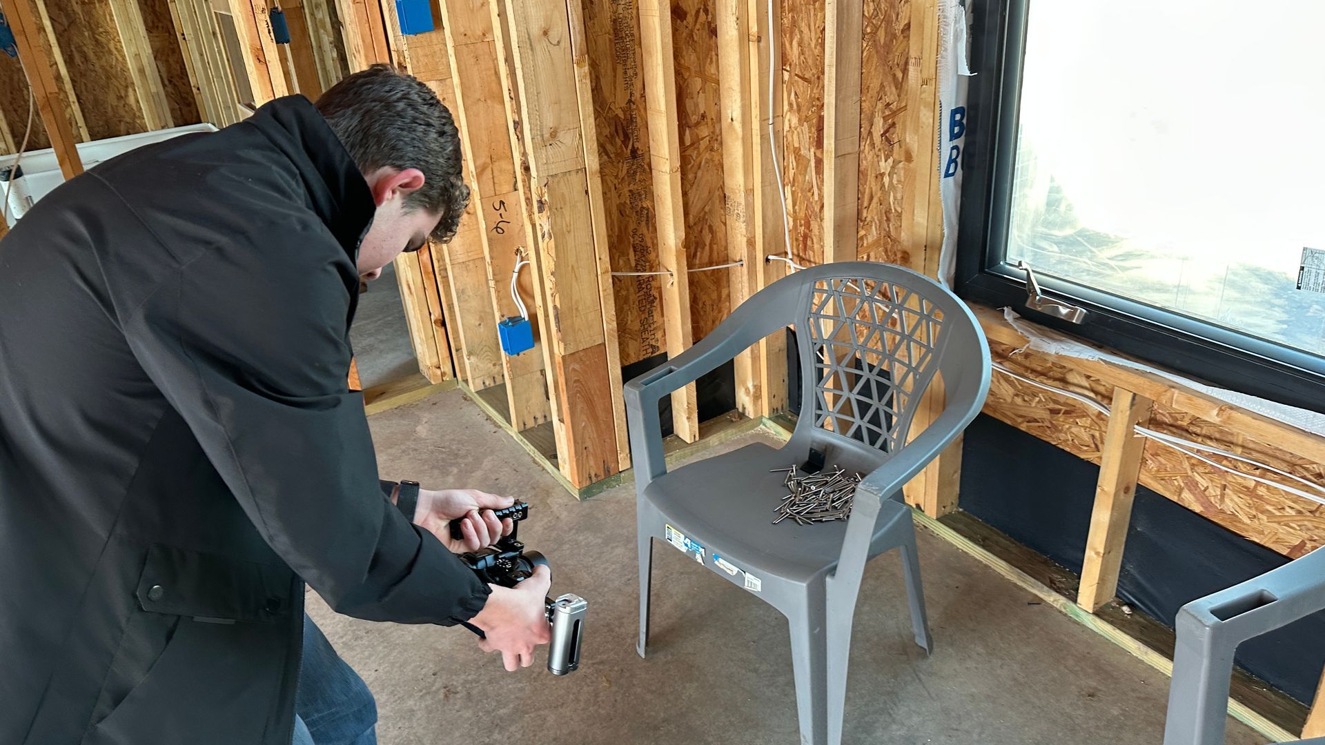 A man is taking a picture of a chair in a room.