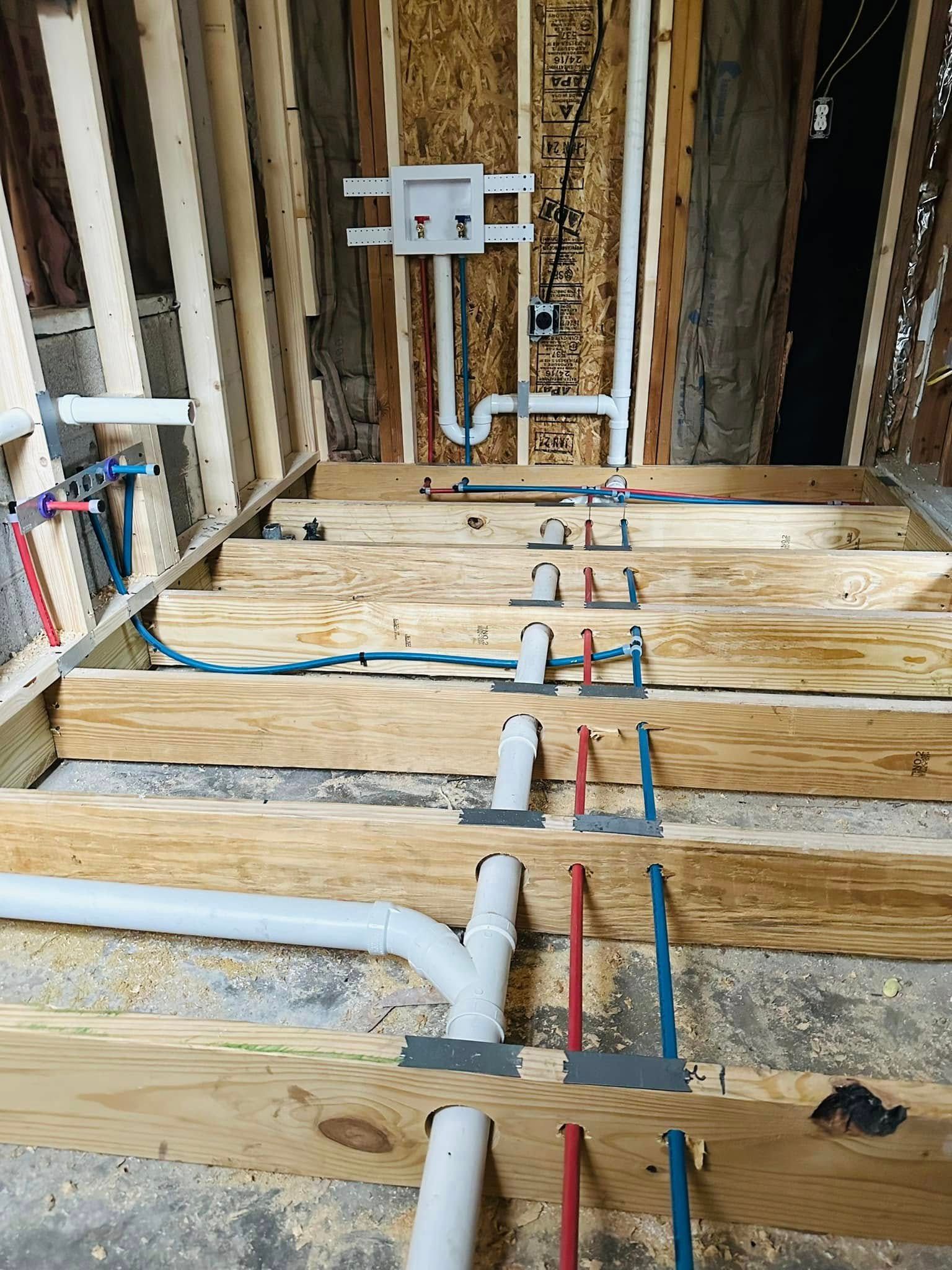 A water heater is sitting in a basement next to a blue pipe.