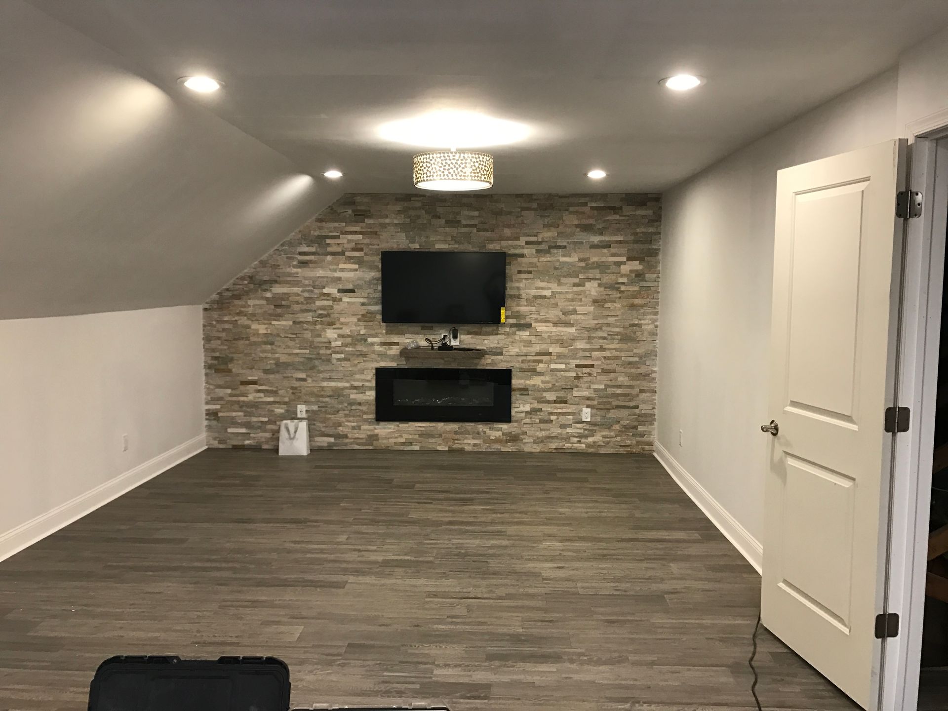 A living room with a fireplace and a flat screen tv on the wall.