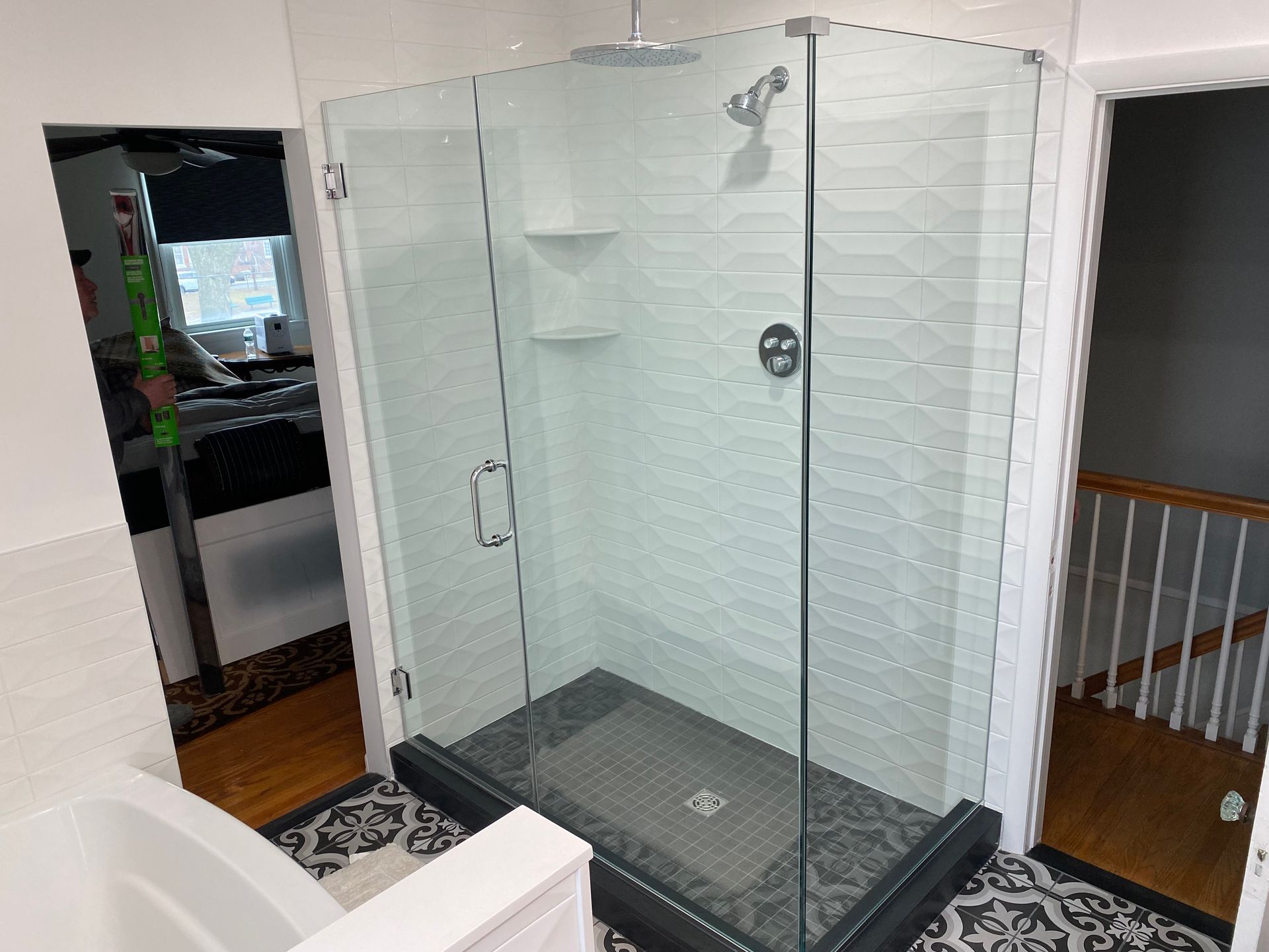 A bathroom with a walk in shower with a glass door