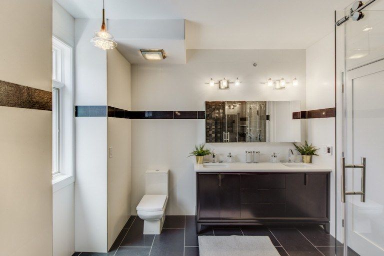 A bathroom with a toilet , sink and mirror