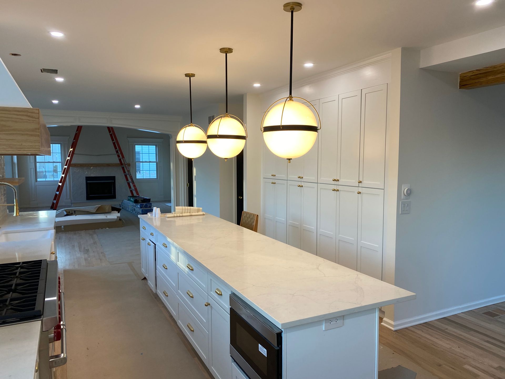 A kitchen with white cabinets and a large island in the middle.