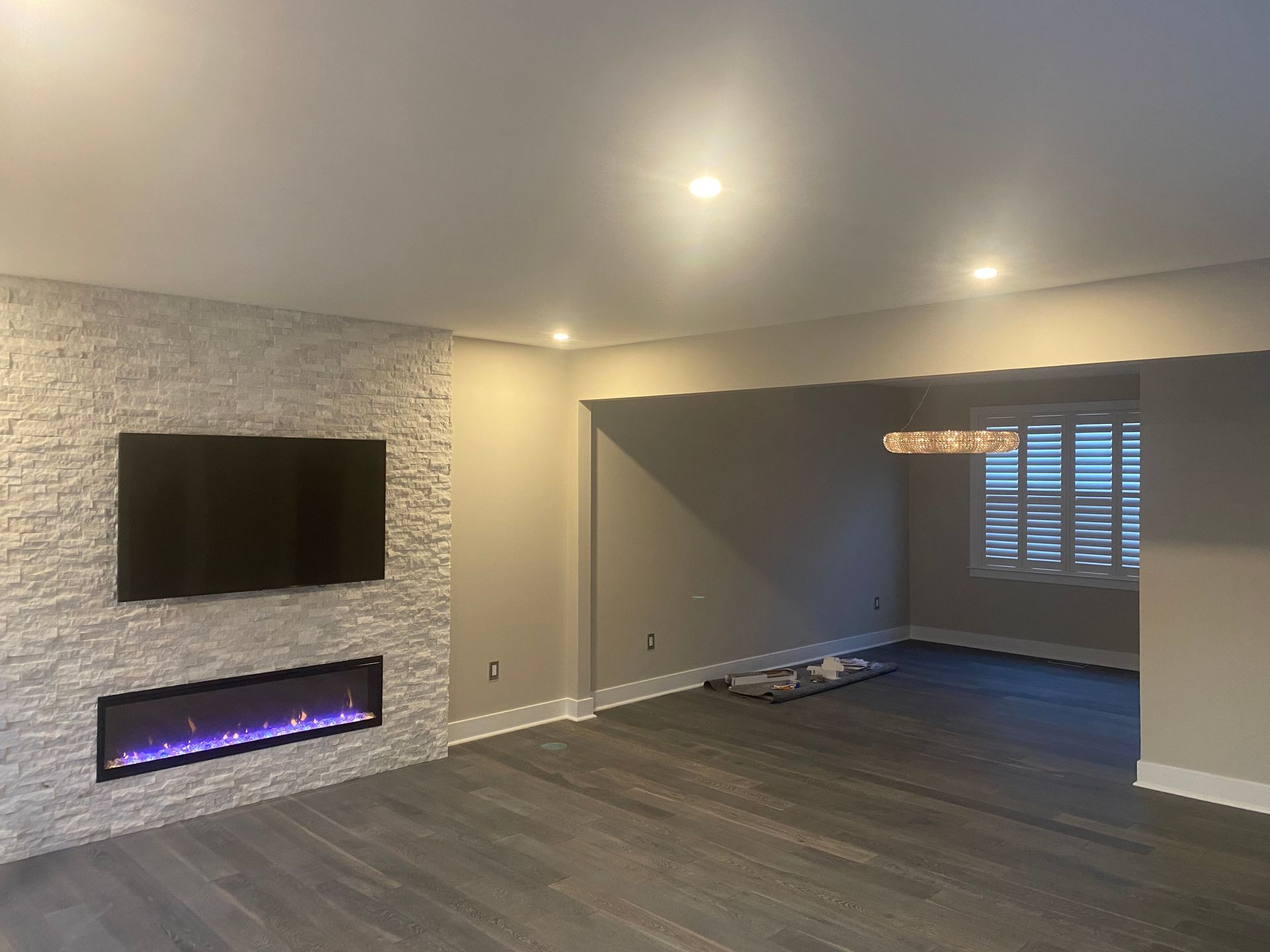A living room with a fireplace and a flat screen tv on the wall.