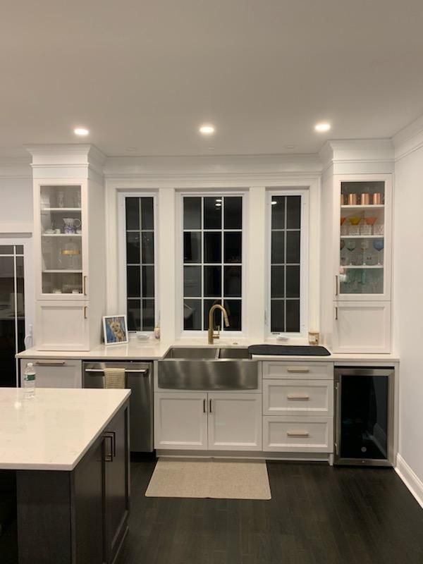 A kitchen with white cabinets and a stainless steel sink