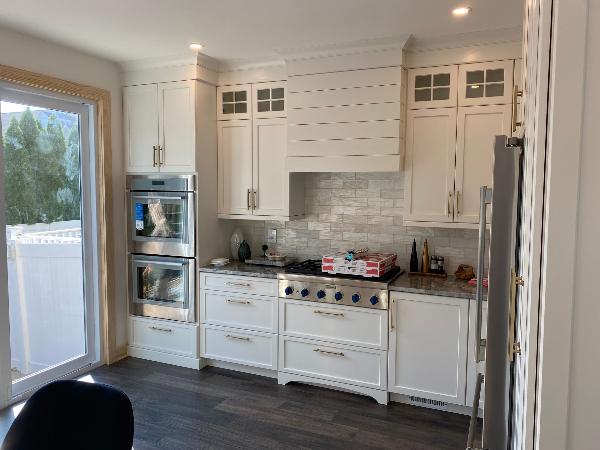 A kitchen with white cabinets and stainless steel appliances