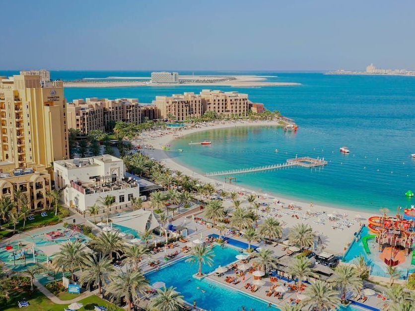 An aerial view of a resort with a water park and a beach.