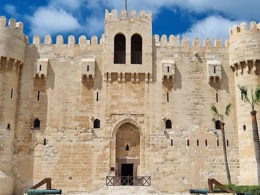 A large stone castle with a blue sky in the background.