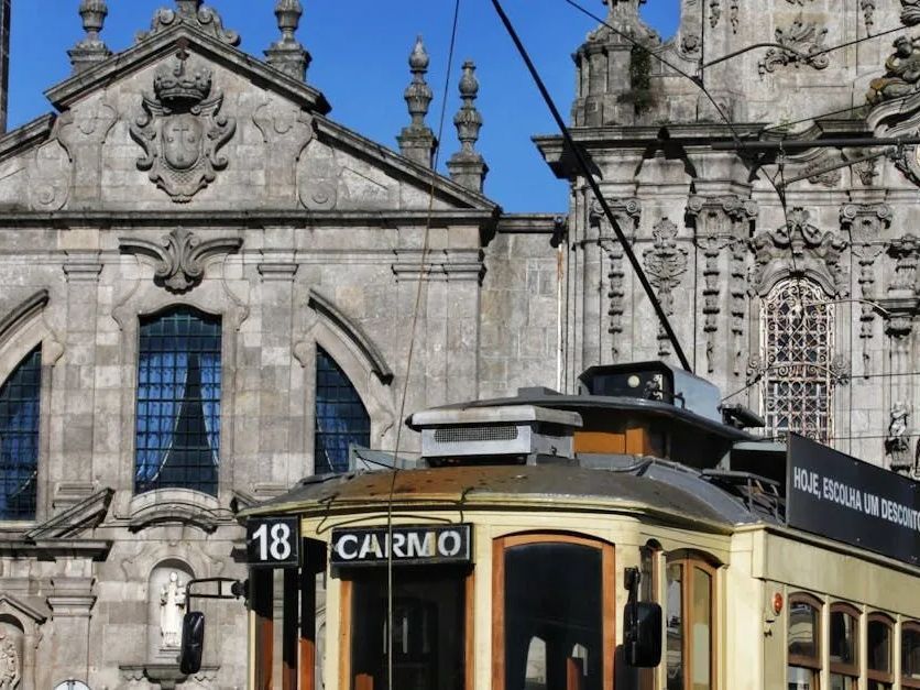 A carno bus is parked in front of a building