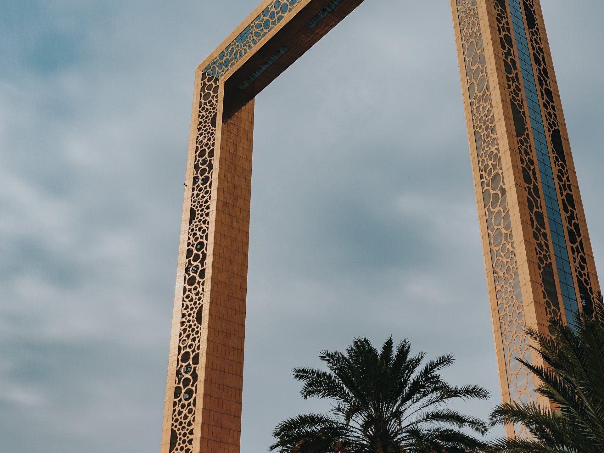 A tall building with a palm tree in front of it.