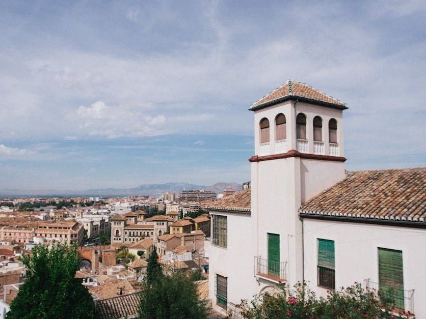 A white building with a tower on top of it overlooking a city.