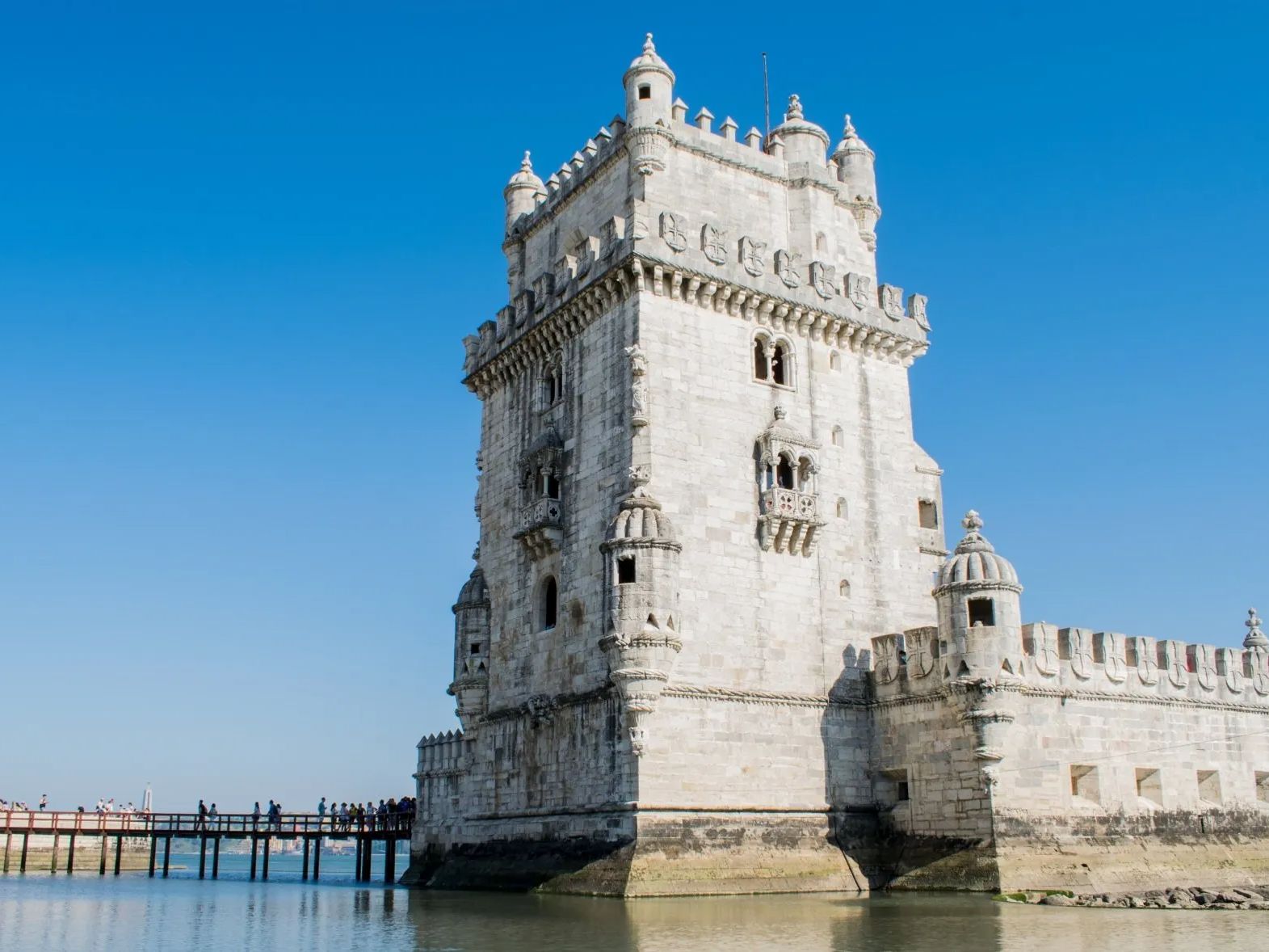 A large white castle is sitting on top of a body of water.