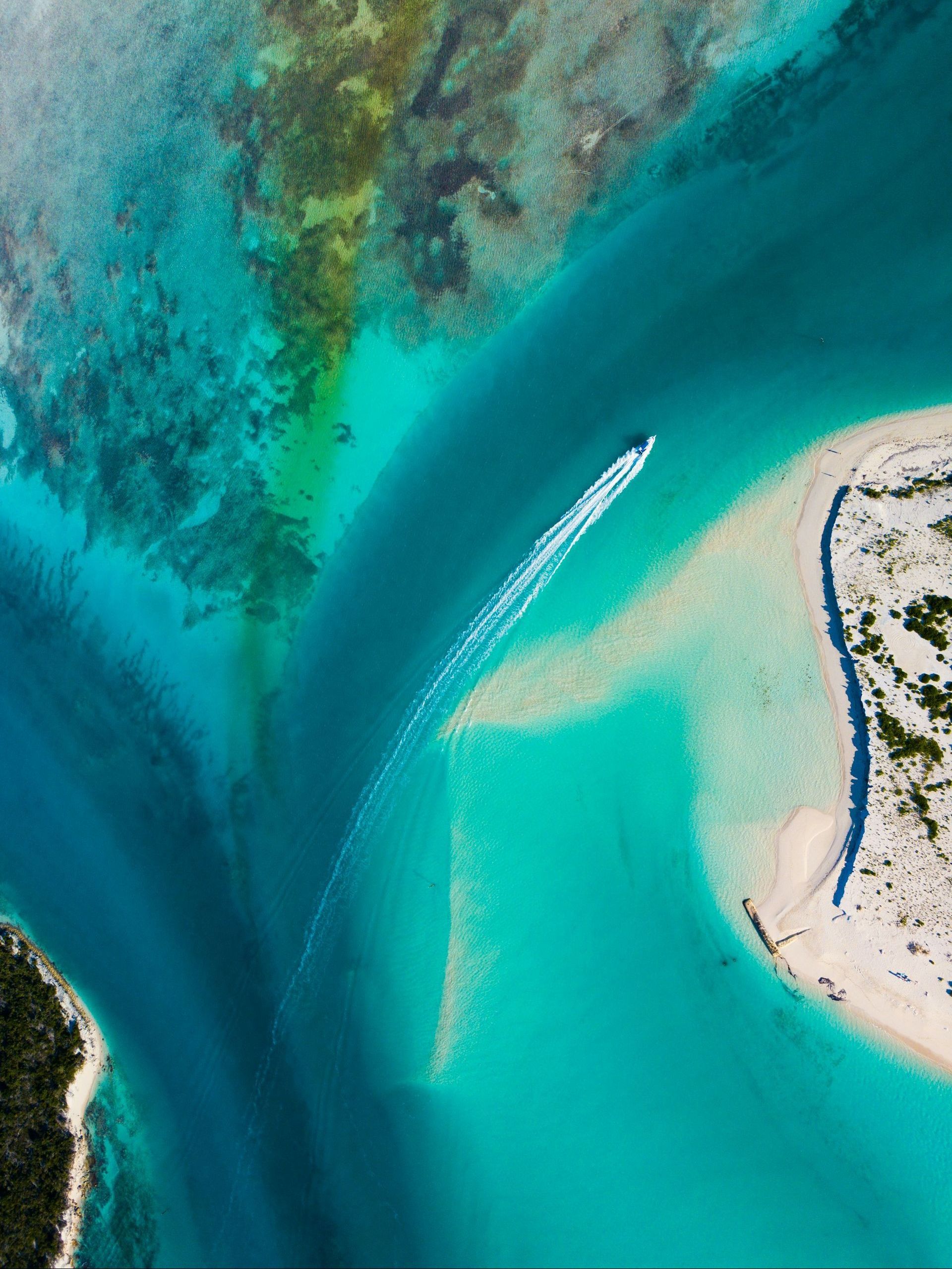 An aerial view of a boat going through a body of water.