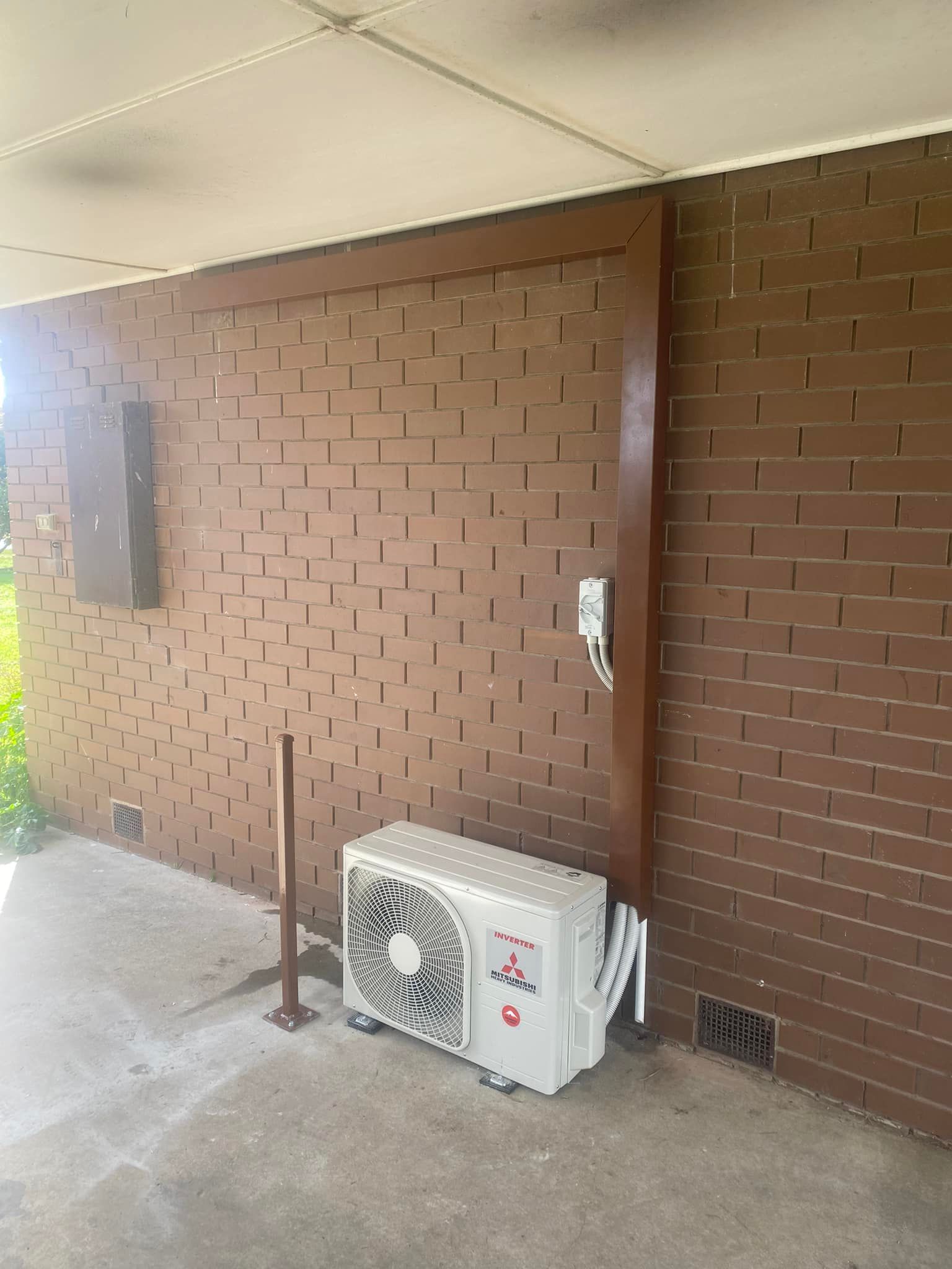 Outdoor Air Conditioning Unit Against a Brick Wall — Elite Electrical Ballarat in Delacombe, VIC
