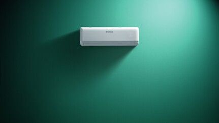 Un condizionatore d'aria bianco e minimalista montato su una parete piatta e uniforme color verde acqua Mattei Vaillant Roma