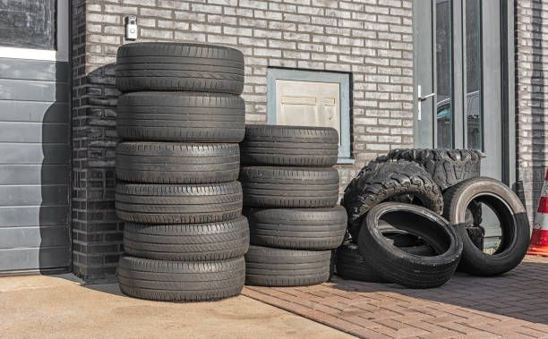 Car tires are stacked on top of each other outside a factory building