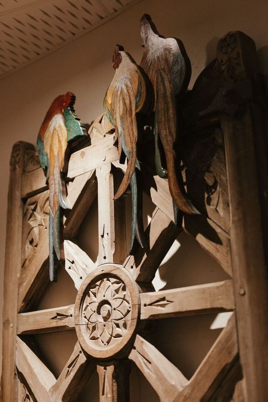 Three birds are sitting on top of a wooden wheel