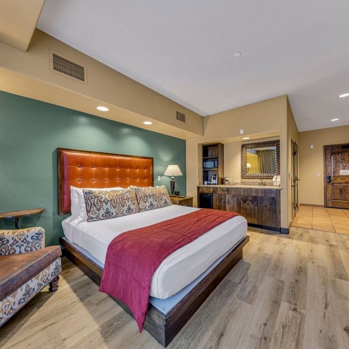 A hotel room with a large bed and a chair