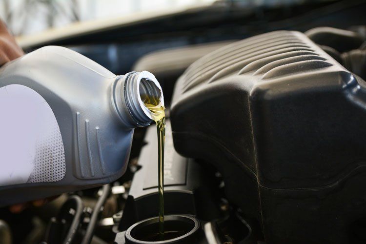 Pouring Oil Into the Car Engine — Jacksonville, FL — Paul Murray Oil Inc