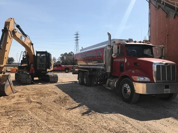 Red Truck Next to an Excavator — Jacksonville, FL — Paul Murray Oil Inc