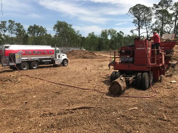 Man Working on a Machine in a Field Next to a Truck — Jacksonville, FL — Paul Murray Oil Inc