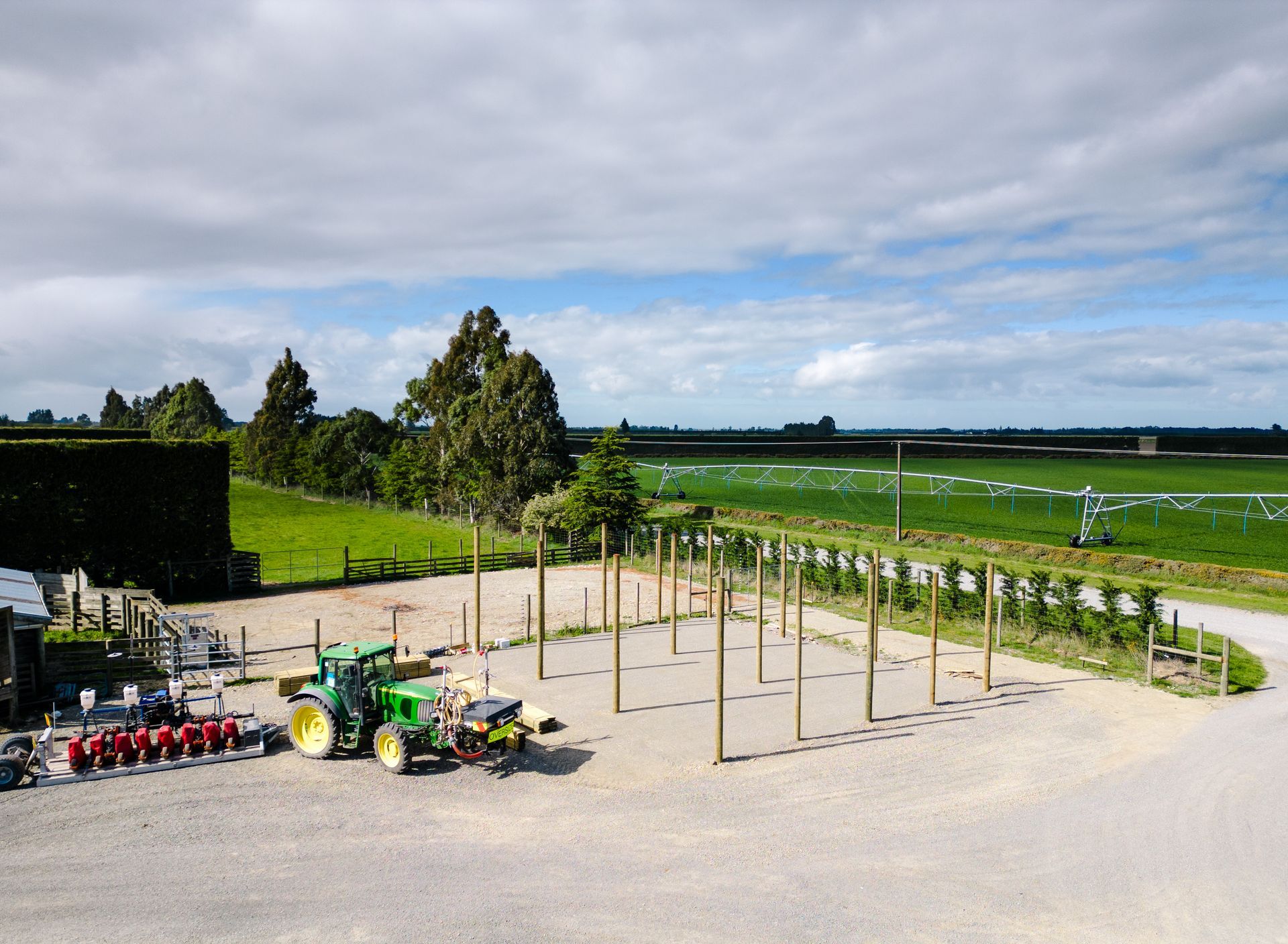 A green john deere tractor is parked in a gravel lot