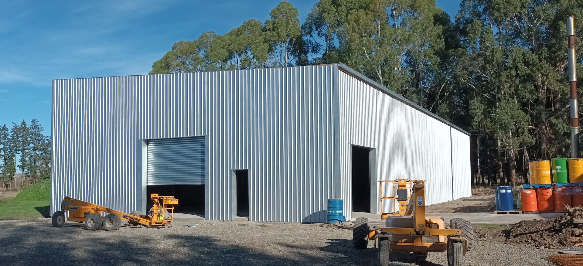 A white building with a yellow tractor in front of it