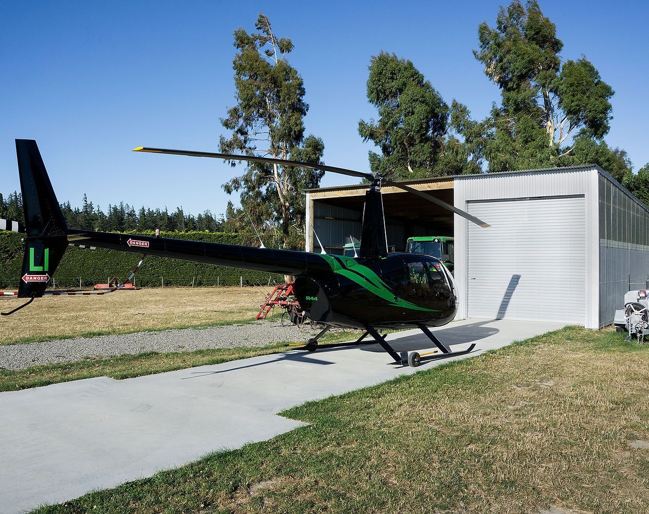 a black and green helicopter with the letter l on the tail