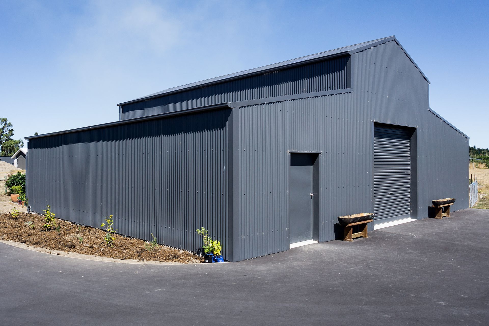 A large gray metal building with a blue sky in the background.