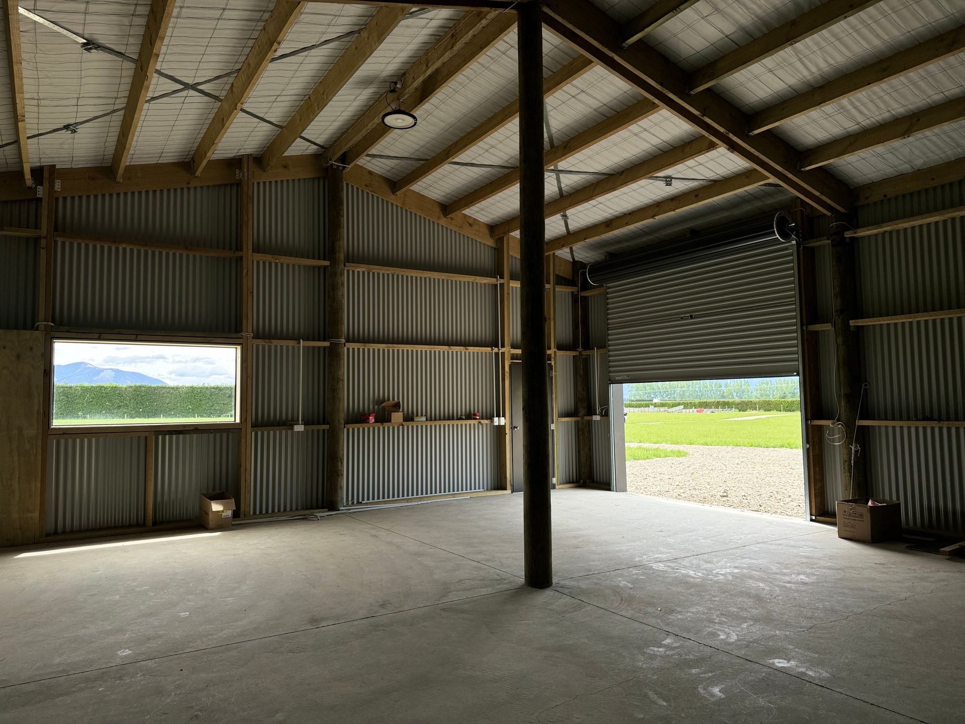 An empty barn with a roll up door and a window