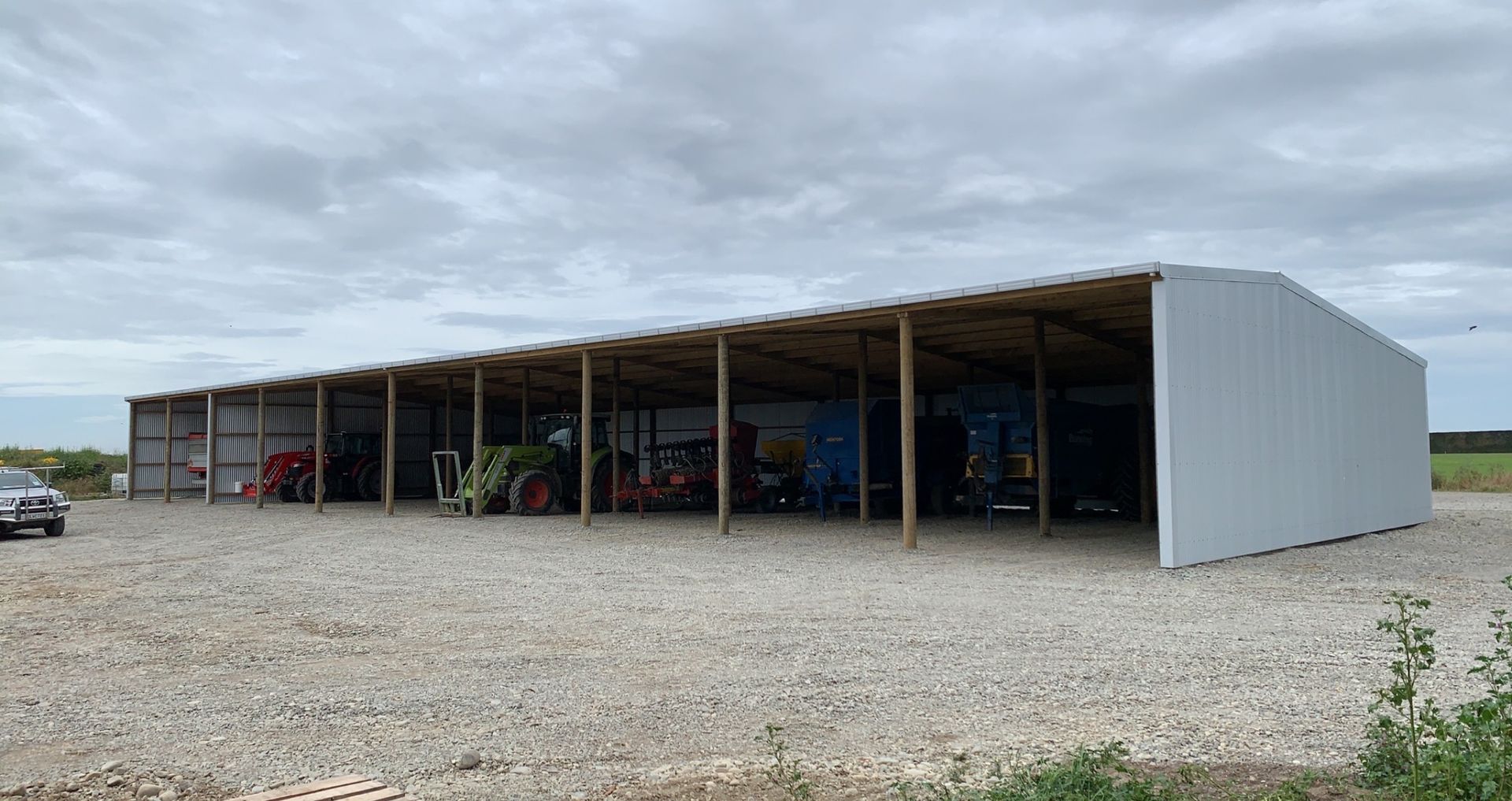 A large white building with a lot of tractors inside of it.