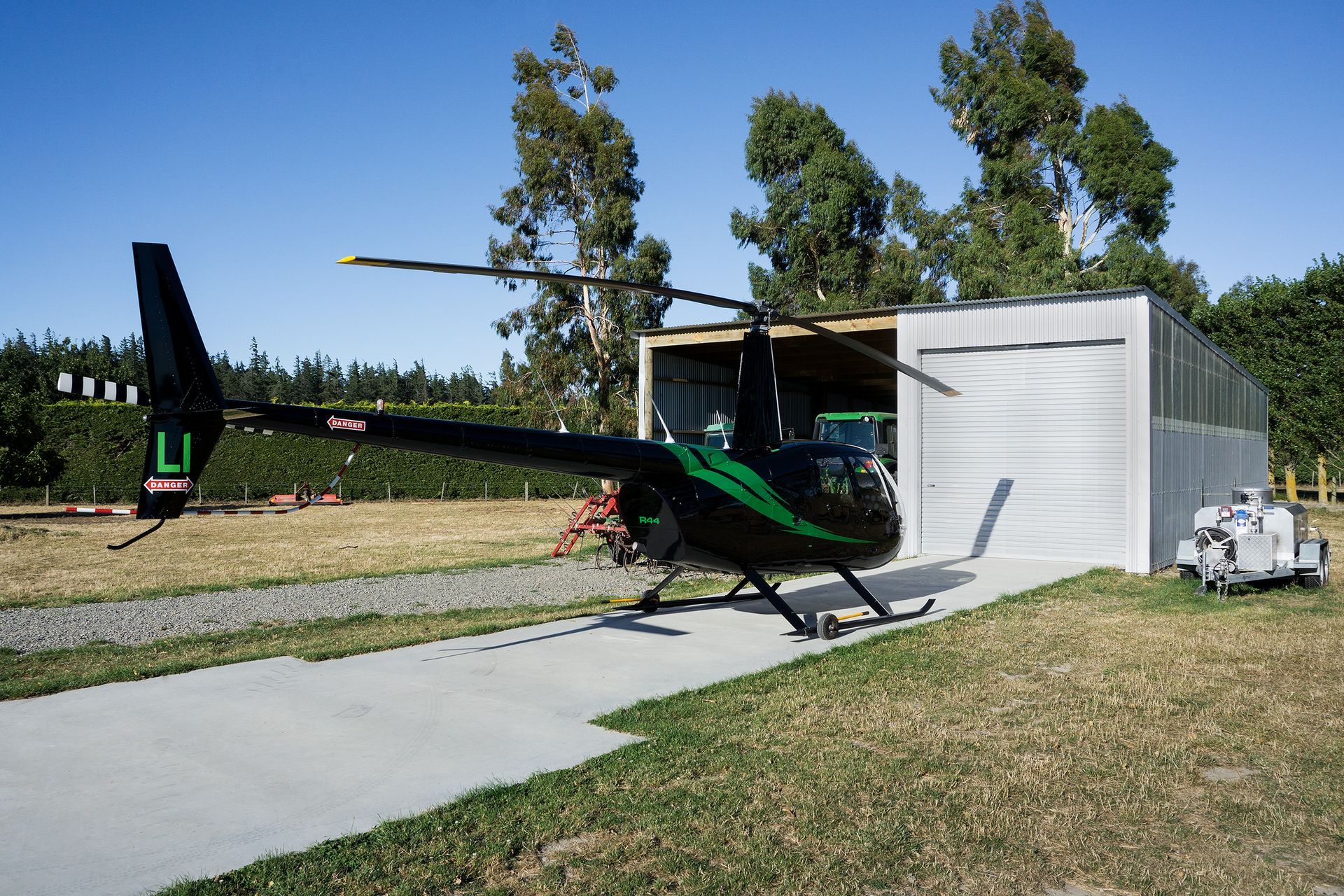 A black and green helicopter with the letter l on the tail