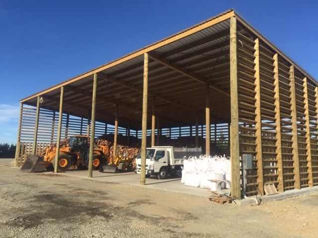 A truck is parked under a large wooden structure