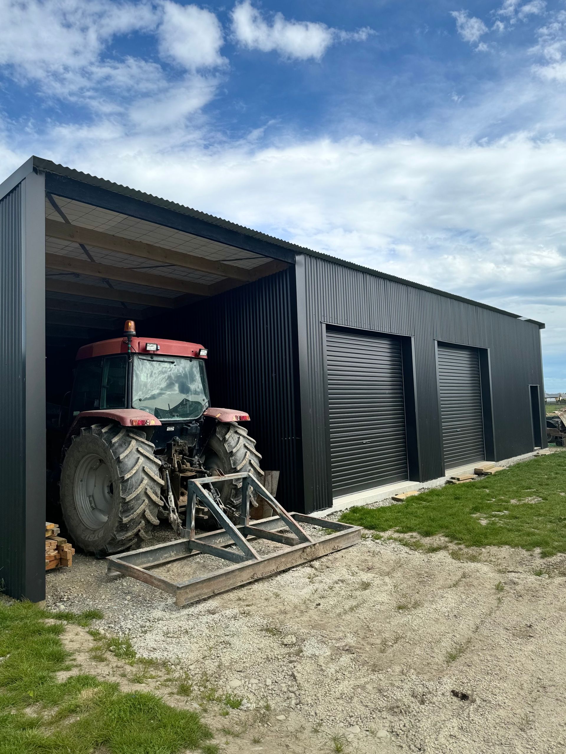 A red tractor is parked in a black garage.
