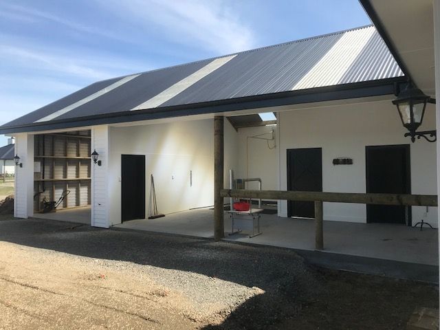 A white building with a black roof and black doors