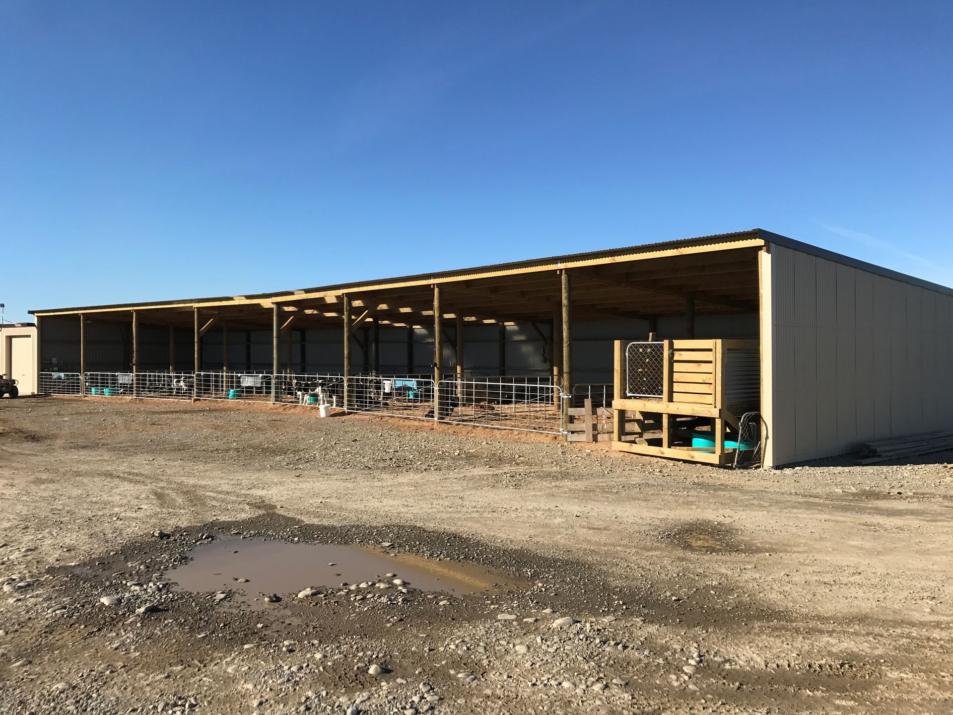 A row of sheds are being built in a dirt field.