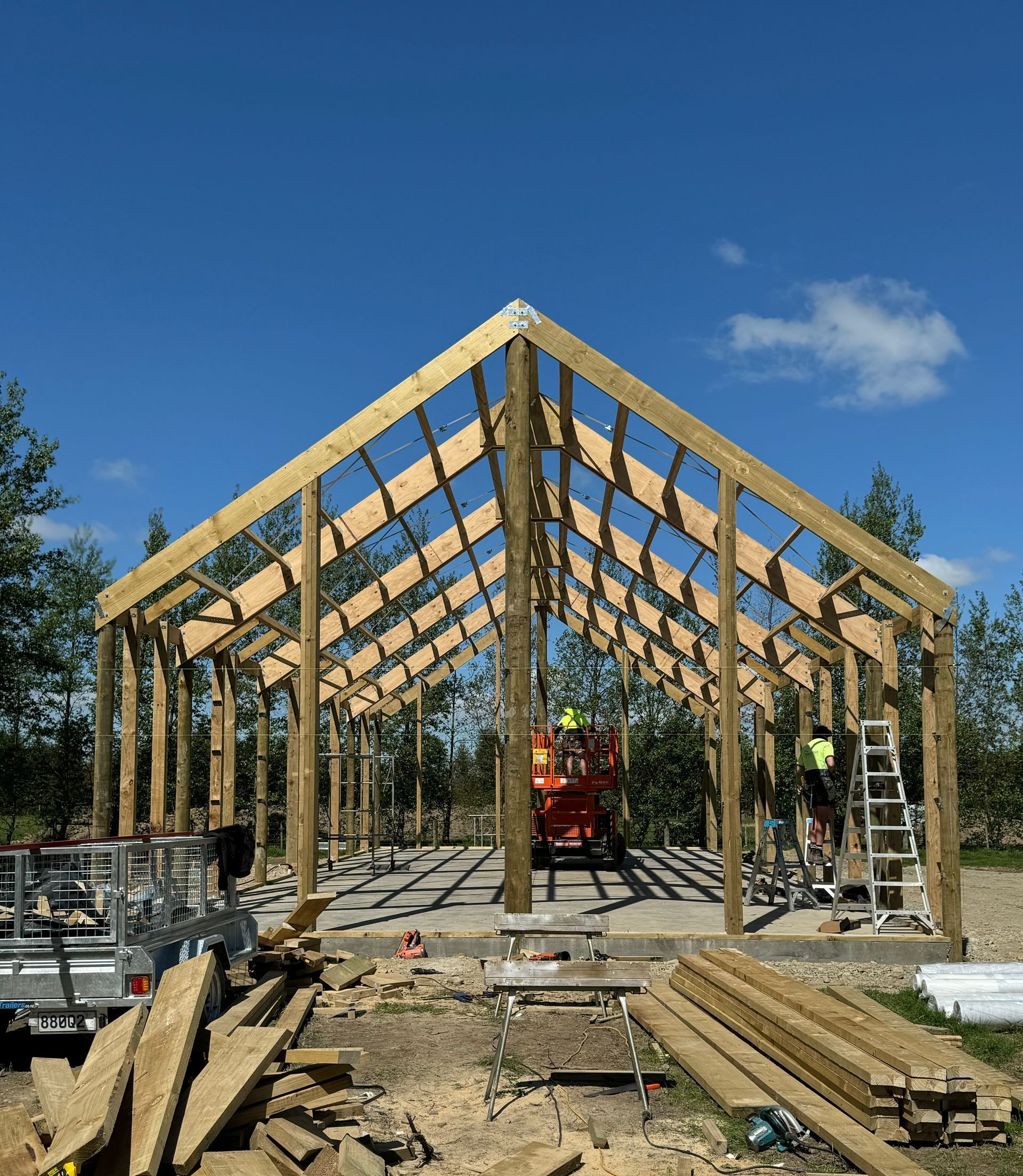 A large wooden structure is being built with a blue sky in the background.