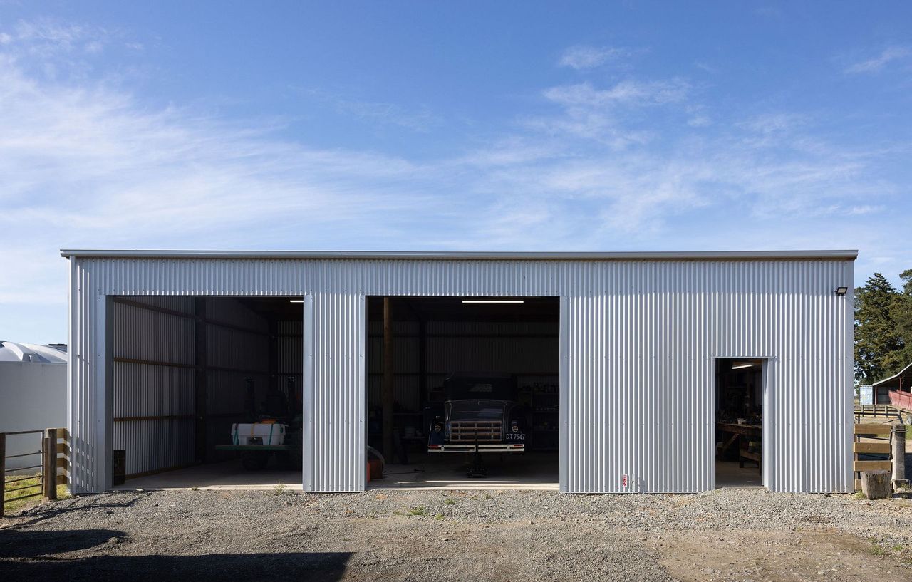 A large metal building with a truck parked inside of it.