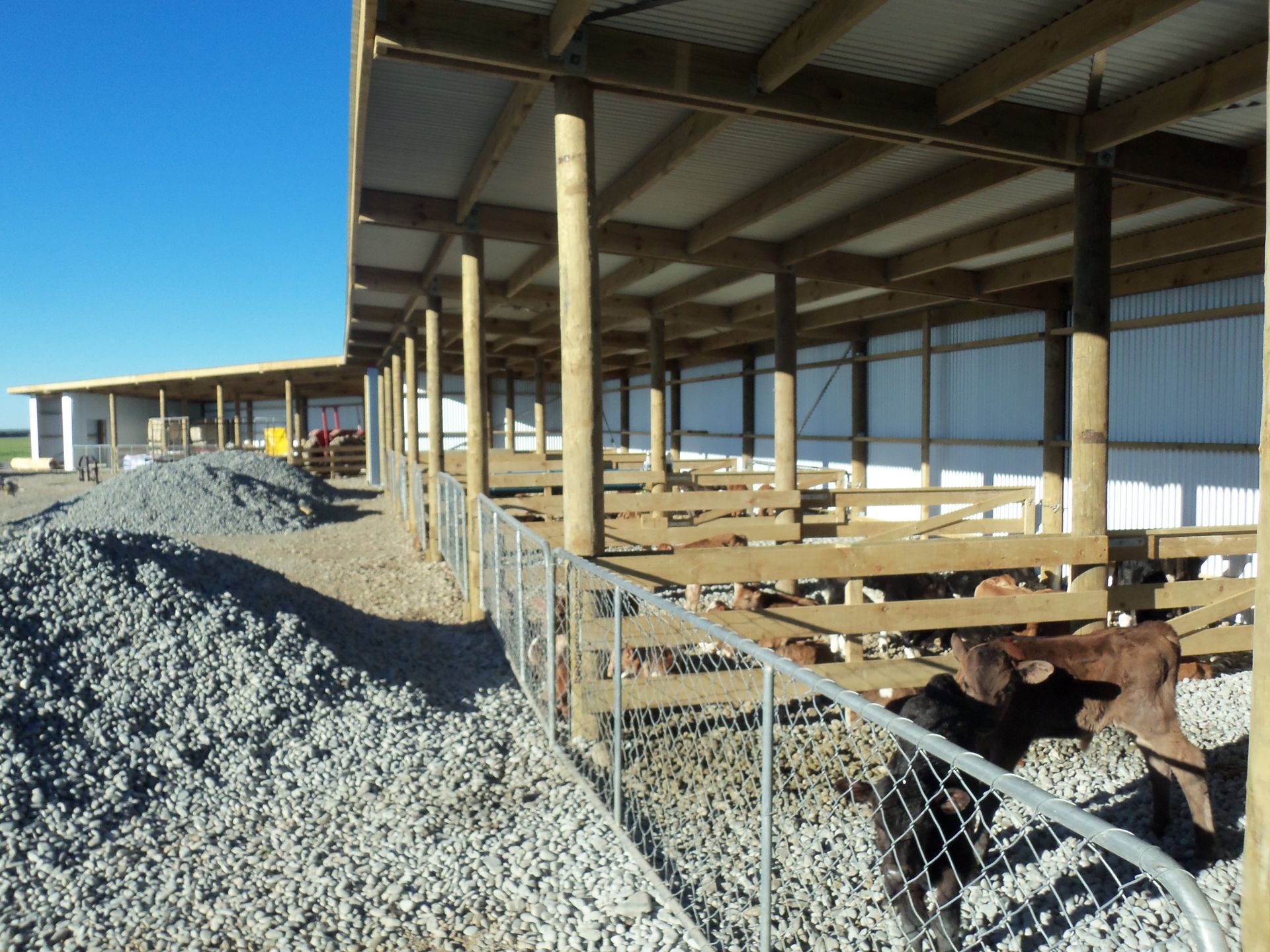 A fenced in area with a pile of gravel in the foreground