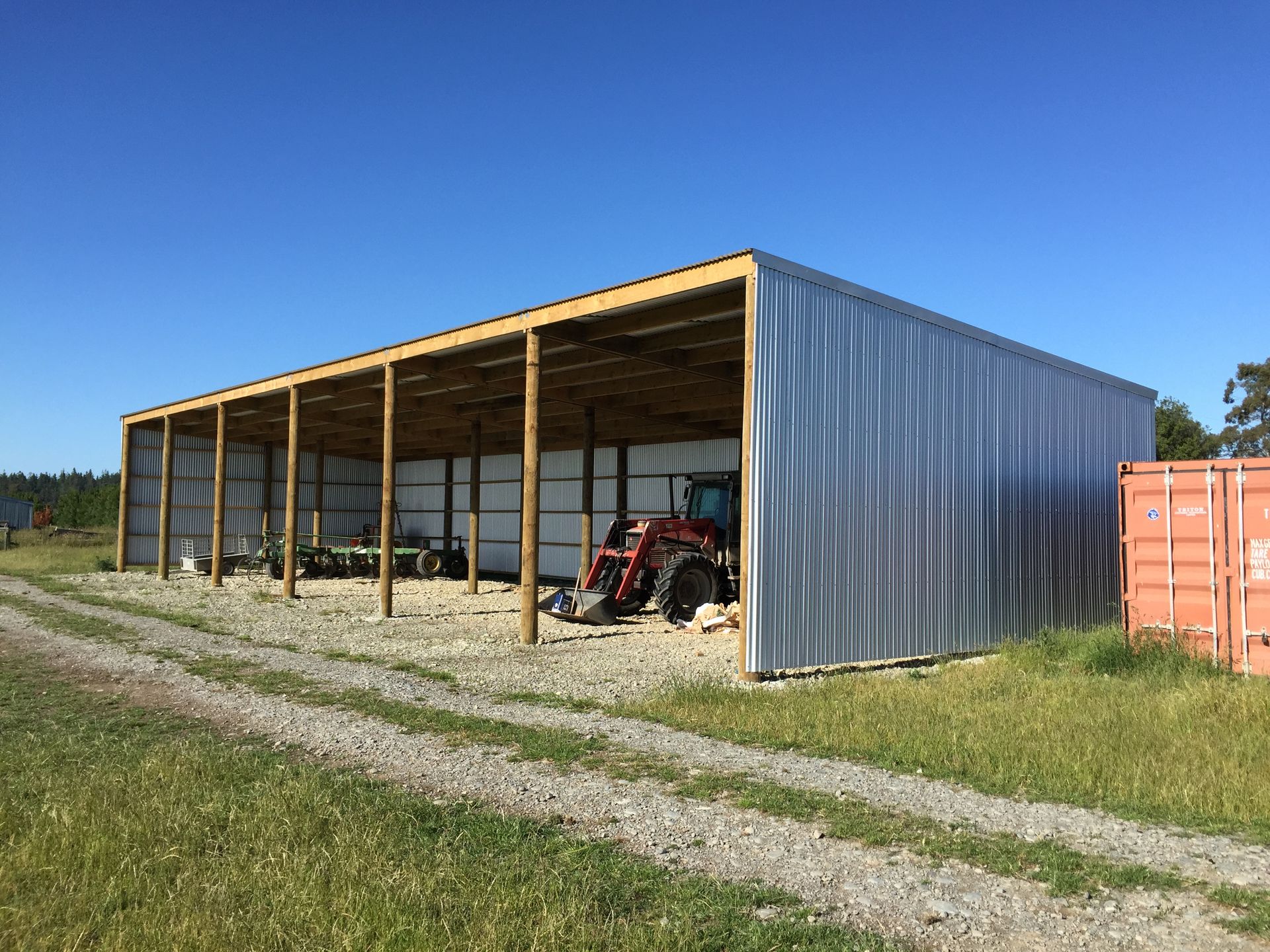 A large metal building with a tractor inside of it.