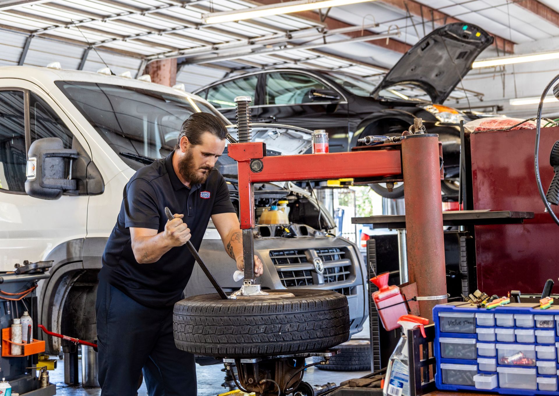 Male technician working on a wheel at a Port Richey, FL AAMCO Center.