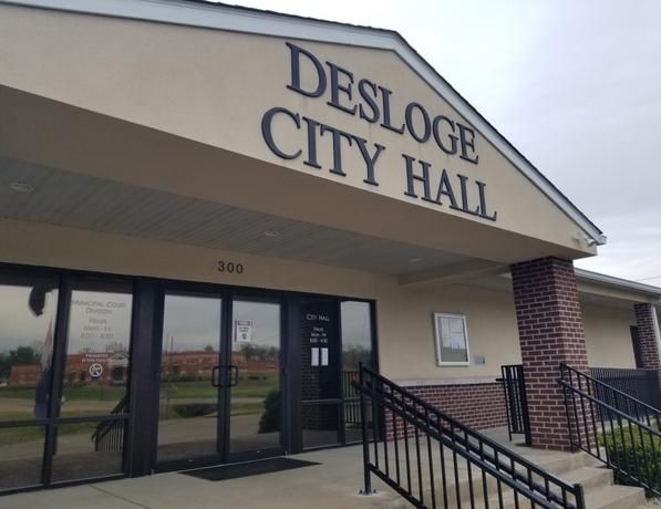 The front of a building that says desloge city hall