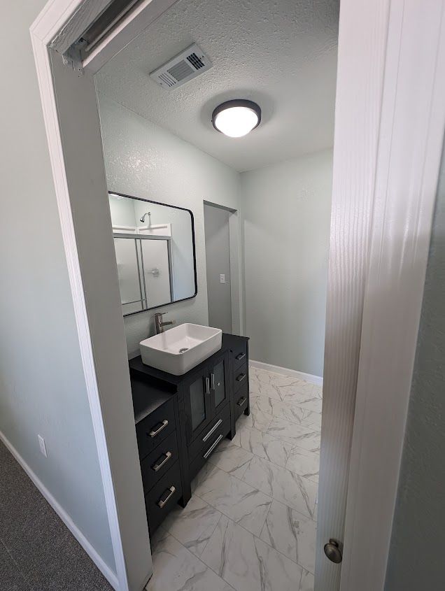 A bathroom with a sink and a mirror in it