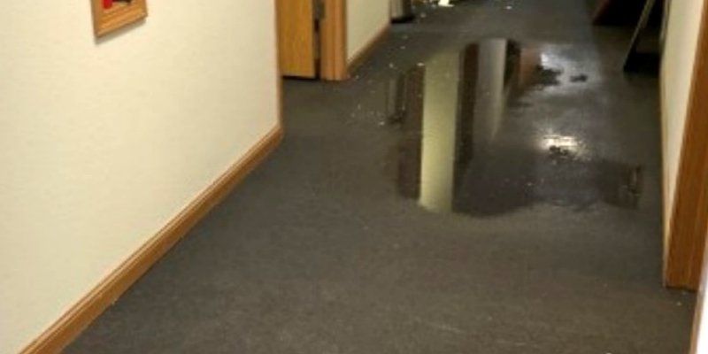 A hallway with a puddle of water on the floor.